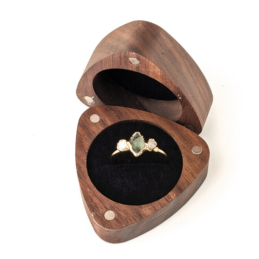 Triangular wooden ring gift box with an engagement ring displayed inside, showcasing a unique design.