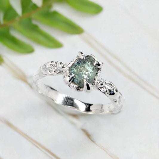 Raw Montana Sapphire silver ring with organic band, showcasing teal blue-green gemstone, perfect for unique engagement.