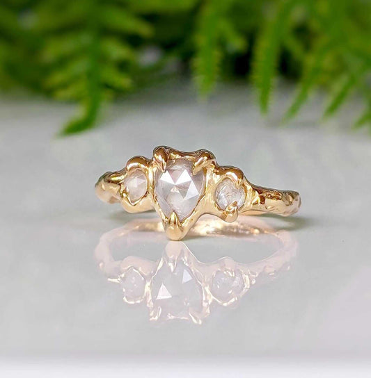 Rustic solid gold engagement ring featuring a heart-shaped diamond and two smaller stones, ideal for a unique proposal.