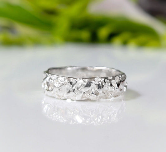 Textured handcrafted molten gold wedding ring showcasing rustic elegance and organic design.