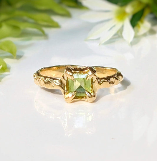 Elegant solid gold Peridot ring with organic textured band and princess-cut stone, perfect for symbolizing timeless love.