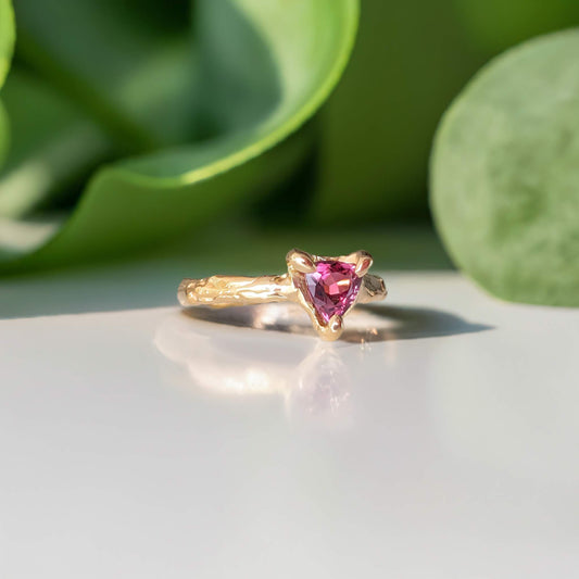Rubellite Tourmaline engagement ring in solid 14k gold with an organic textured band, featuring a trilliant shaped gemstone.