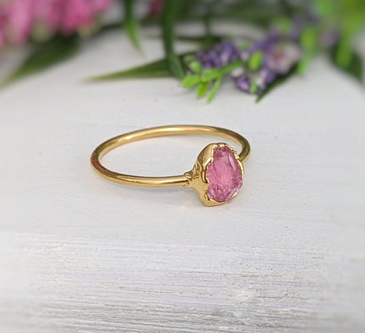 Raw pink spinel ring with gold setting, showcasing natural blush hues and unpolished edges, perfect for gifts.