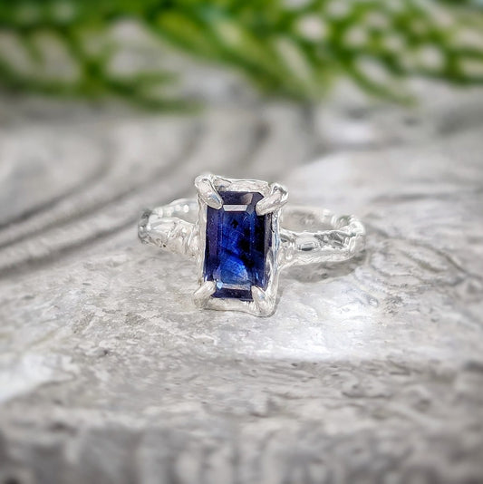 Blue sapphire engagement ring in solid sterling silver with textured band, showcasing a unique emerald-shaped design.