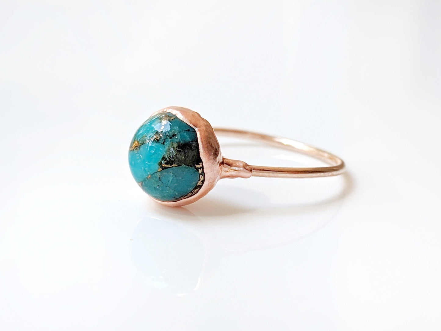 Natural turquoise ring with a unique 10mm stone set on a copper band, showcasing vibrant colors and textures.