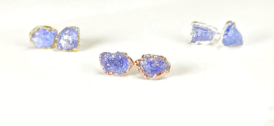 Handcrafted raw Tanzanite stud earrings in silver and rose gold settings, showcasing natural December birthstones.