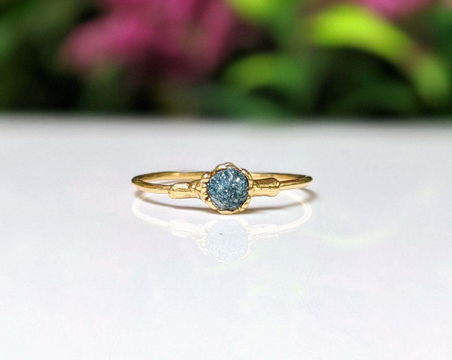 Raw blue diamond engagement ring on an 18k gold band, handcrafted and unique for special occasions.