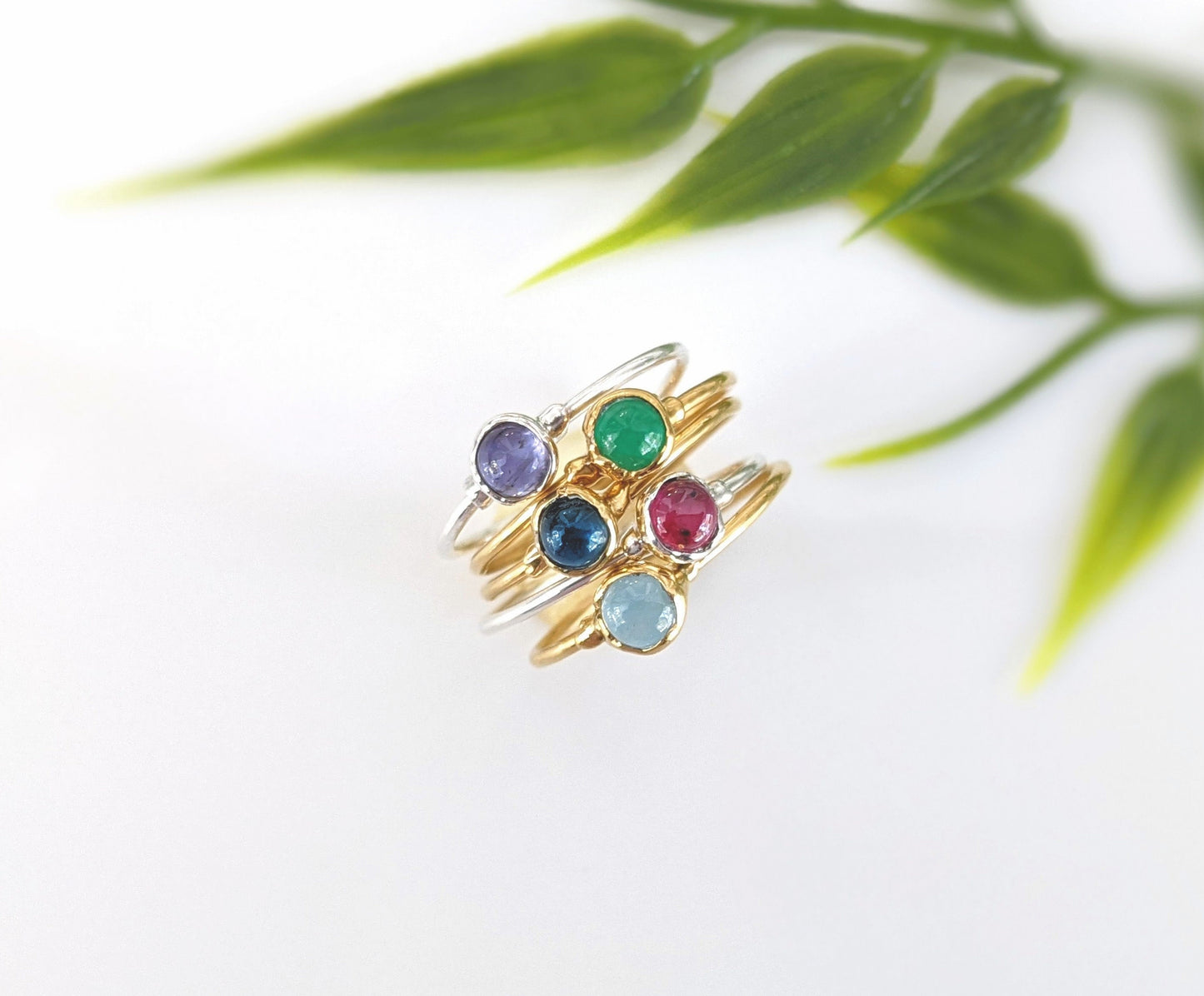 Dainty sapphire stacking ring with multiple colorful gemstones on gold and silver bands, perfect for everyday wear.