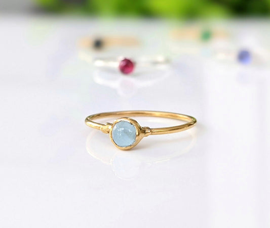 Dainty aquamarine stacking ring on a gold band, perfect for everyday wear or as a March birthstone ring.