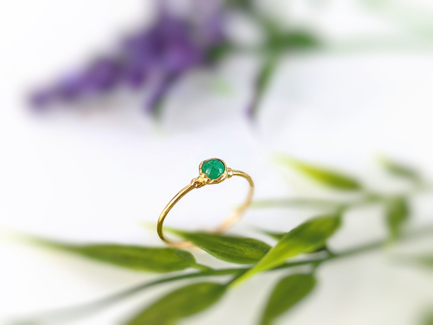 Dainty gold stacking ring featuring a natural green Emerald gemstone on a delicate band.