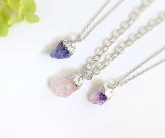 Handcrafted raw crystal and gemstone necklaces on Sterling Silver chains, featuring amethyst and rose quartz stones.