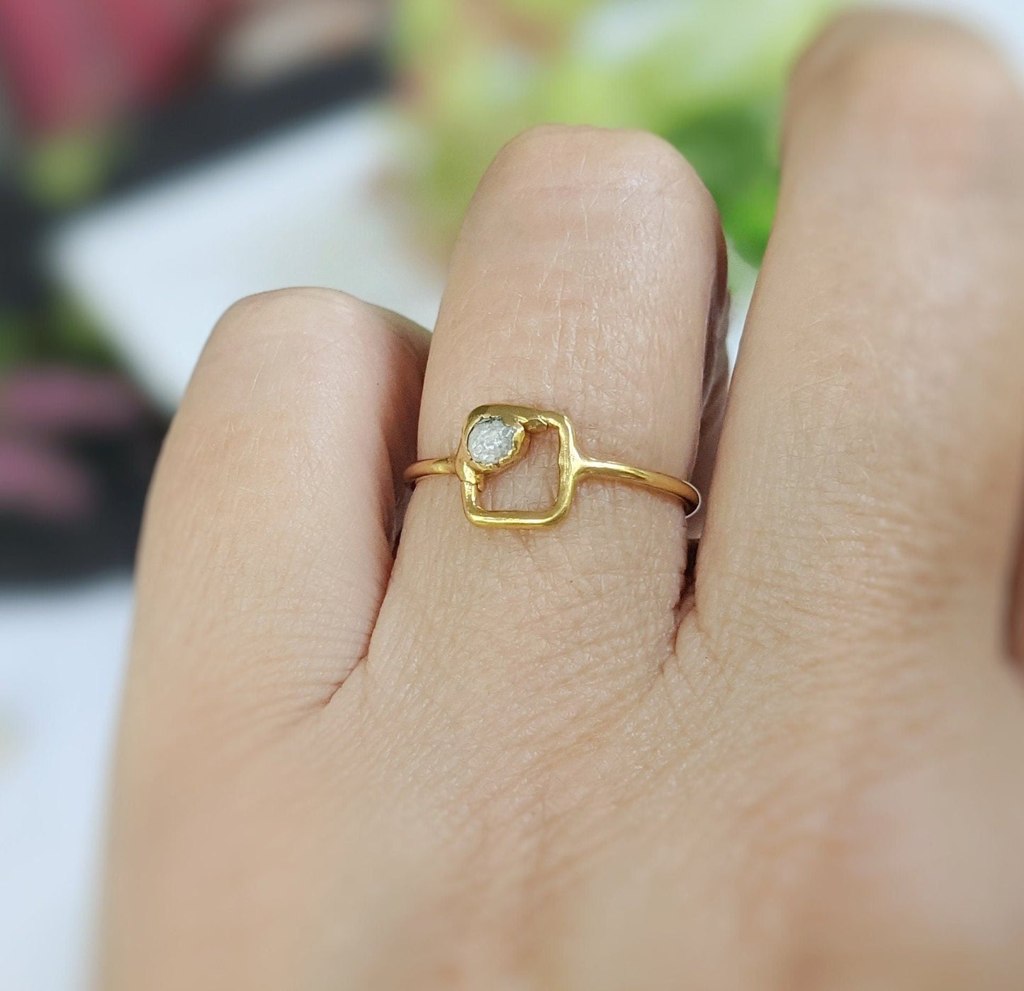 Minimalist solid gold square ring featuring a raw diamond, elegant design, and dainty appearance.