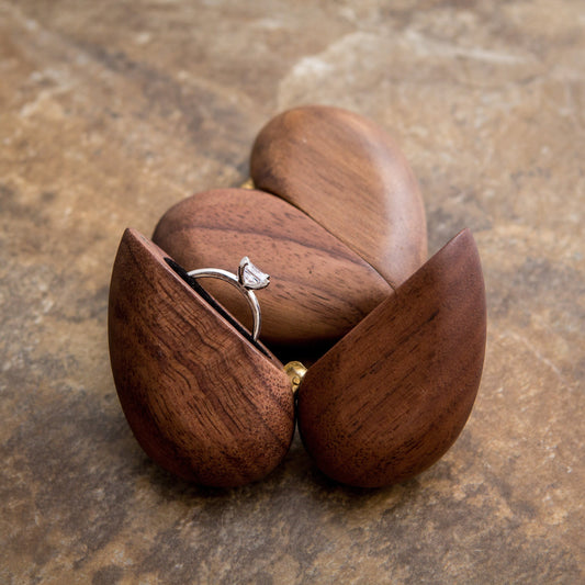 Wooden heart-shaped ring box with an engagement ring inside, perfect for gifts.