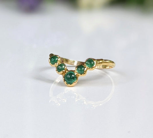 Emerald Chevron wedding ring set in solid gold featuring five vibrant emerald stones arranged in a delicate chevron design.
