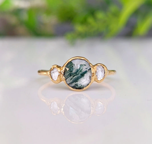 Handcrafted Moss Agate ring set in 18k Gold with two raw Herkimer diamonds, showcasing unique and rustic elegance.