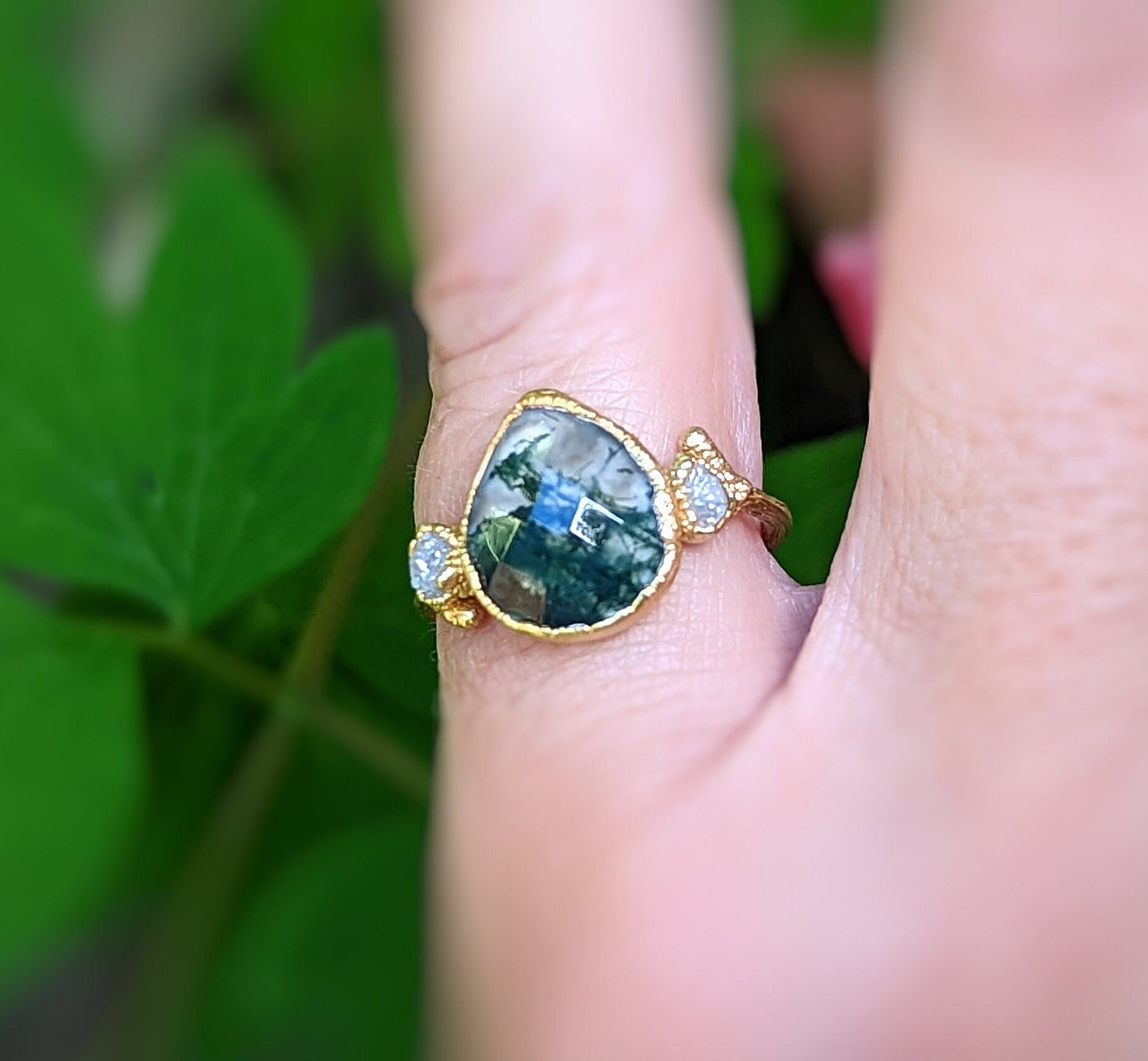 Moss Agate and raw diamond gold twig ring, rustic nature-inspired engagement ring on hand.