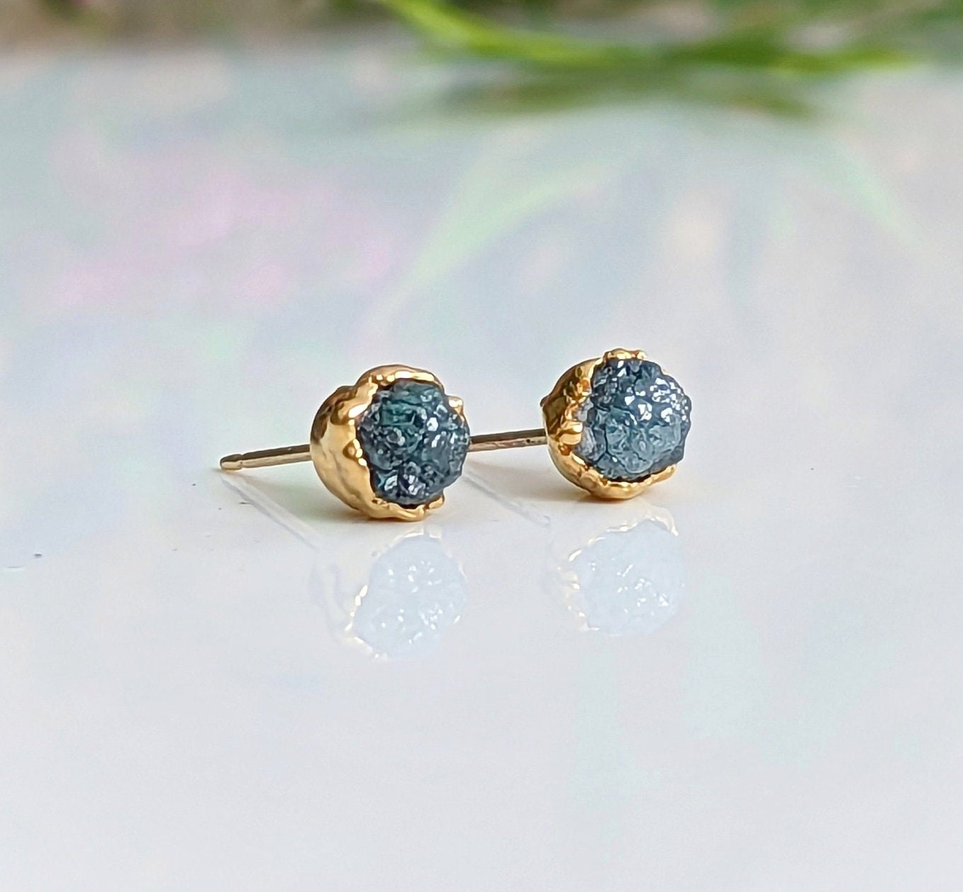 Raw blue diamond stud earrings in gold setting, perfect for bridal or casual wear, radiating timeless beauty.