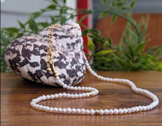 Delicate freshwater pearl necklace resting on a heart-shaped shell, symbolizing love and elegance.