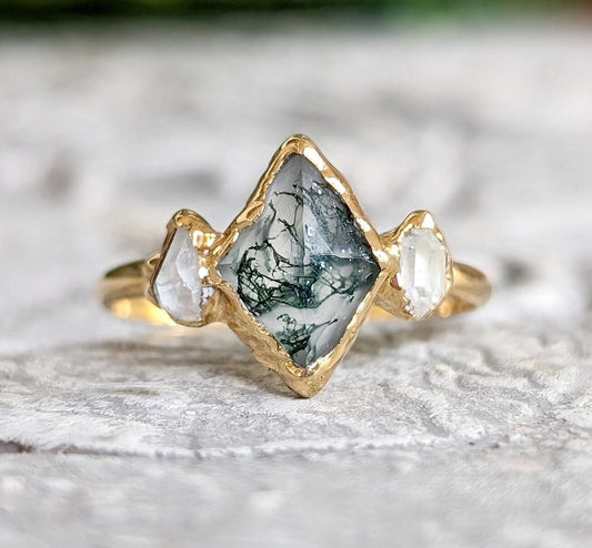 Lozenge shape Moss Agate engagement ring with Herkimer diamonds on a gold band.