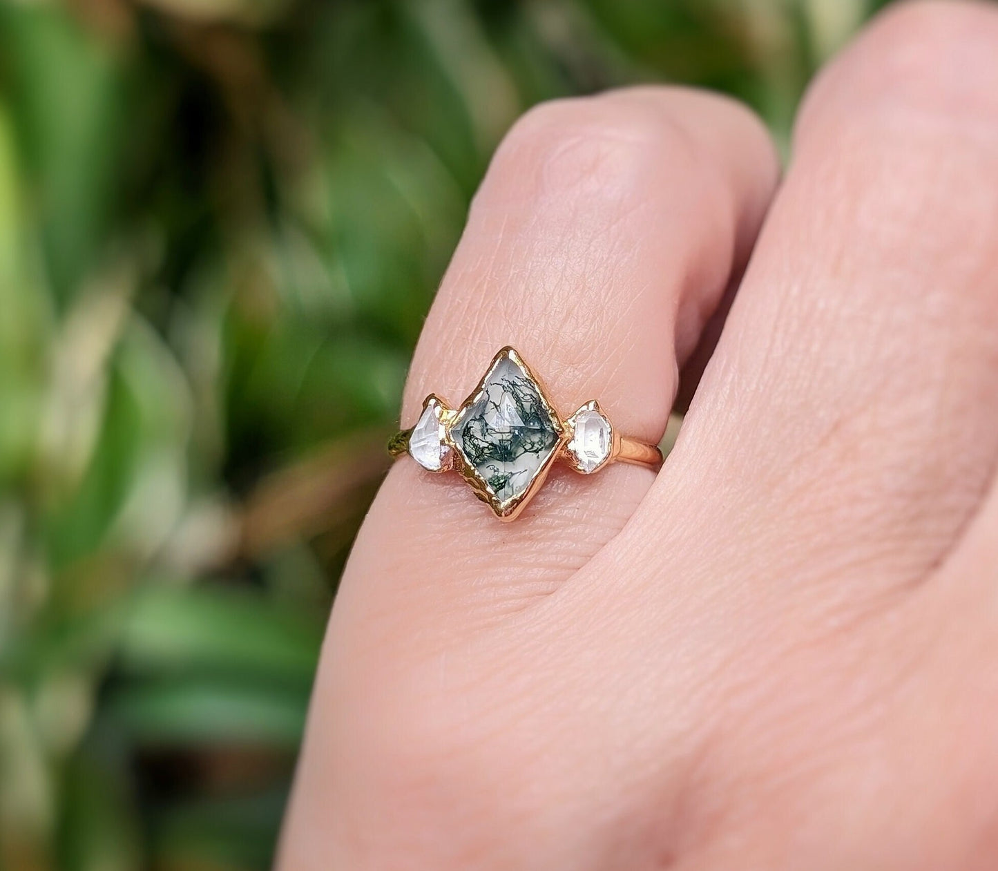 Lozenge shape Moss Agate engagement ring with Herkimer diamonds on 14k gold band, showcased on a hand.