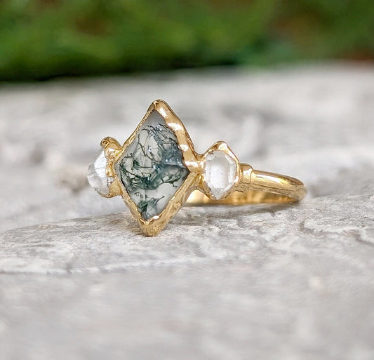 Moss Agate and Herkimer diamond engagement ring in lozenge shape on a gold band, showcasing organic beauty.