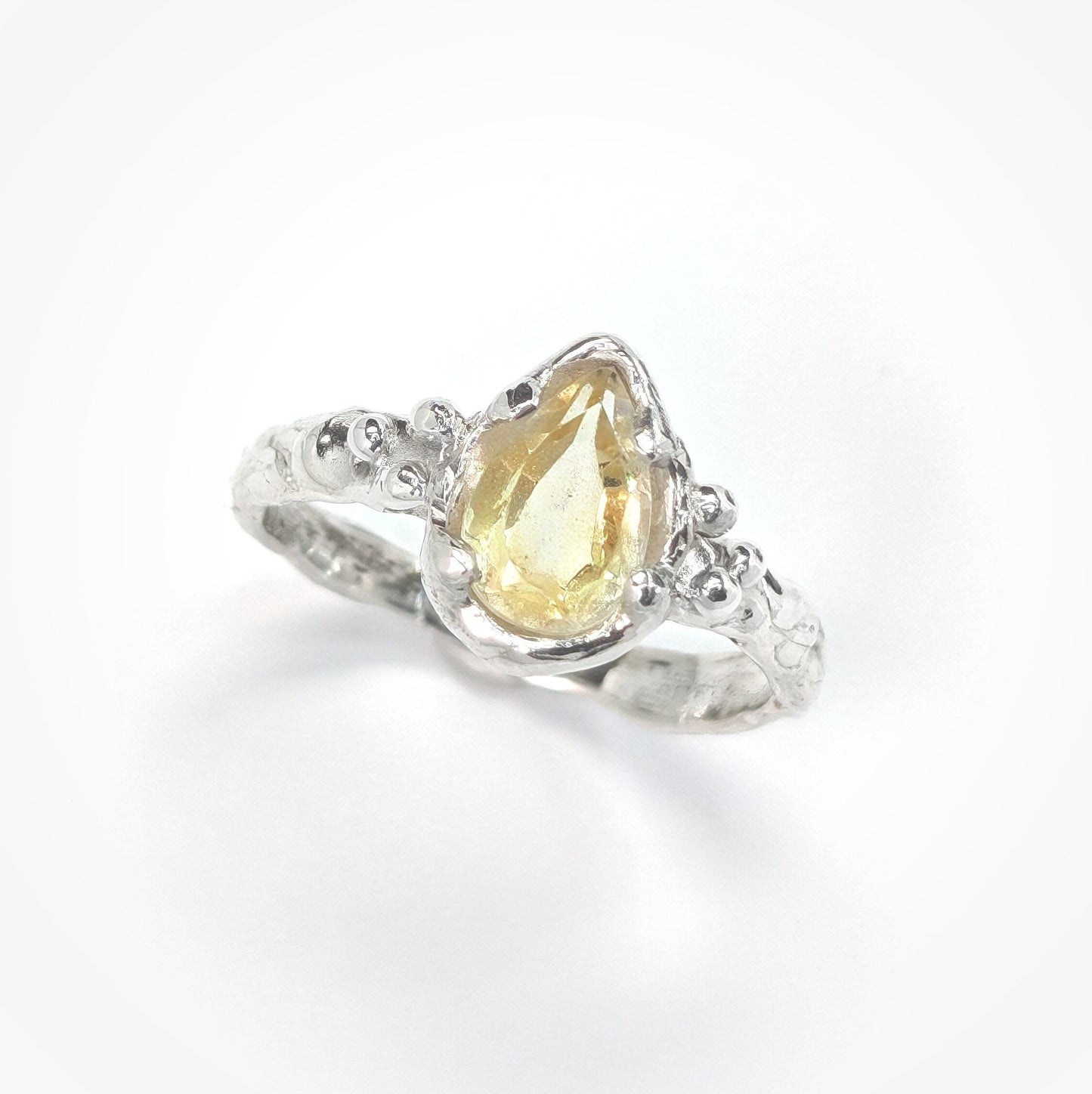Solid 14k Gold citrine ring featuring a pear-shaped yellow crystal and organic textured band.