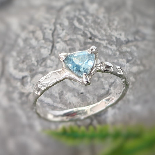Handcrafted solid silver Aquamarine ring with organic texture and trilliant shape, symbolizing timeless love.