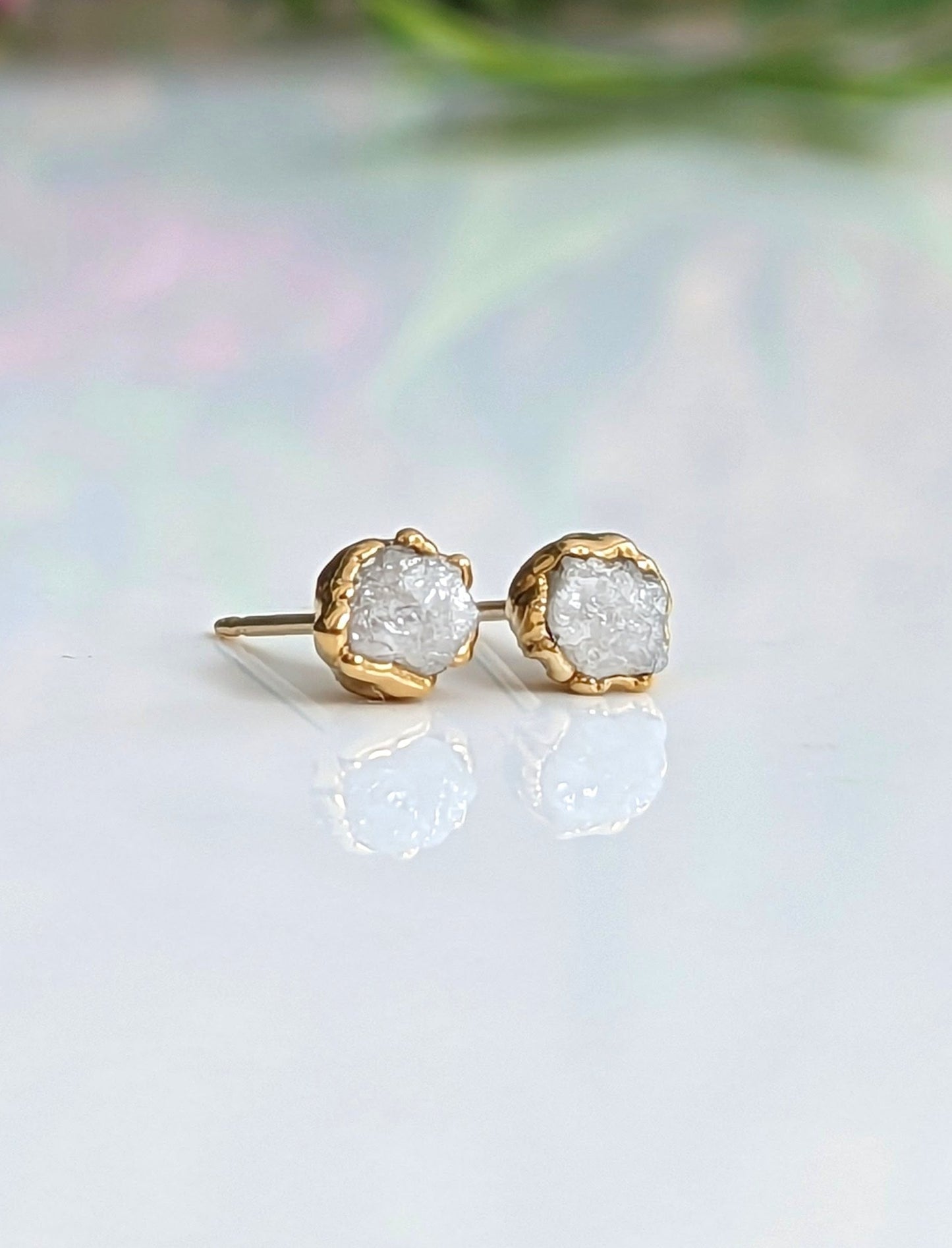 Handcrafted raw diamond stud earrings in gold settings, showcasing uncut natural beauty and timeless elegance.