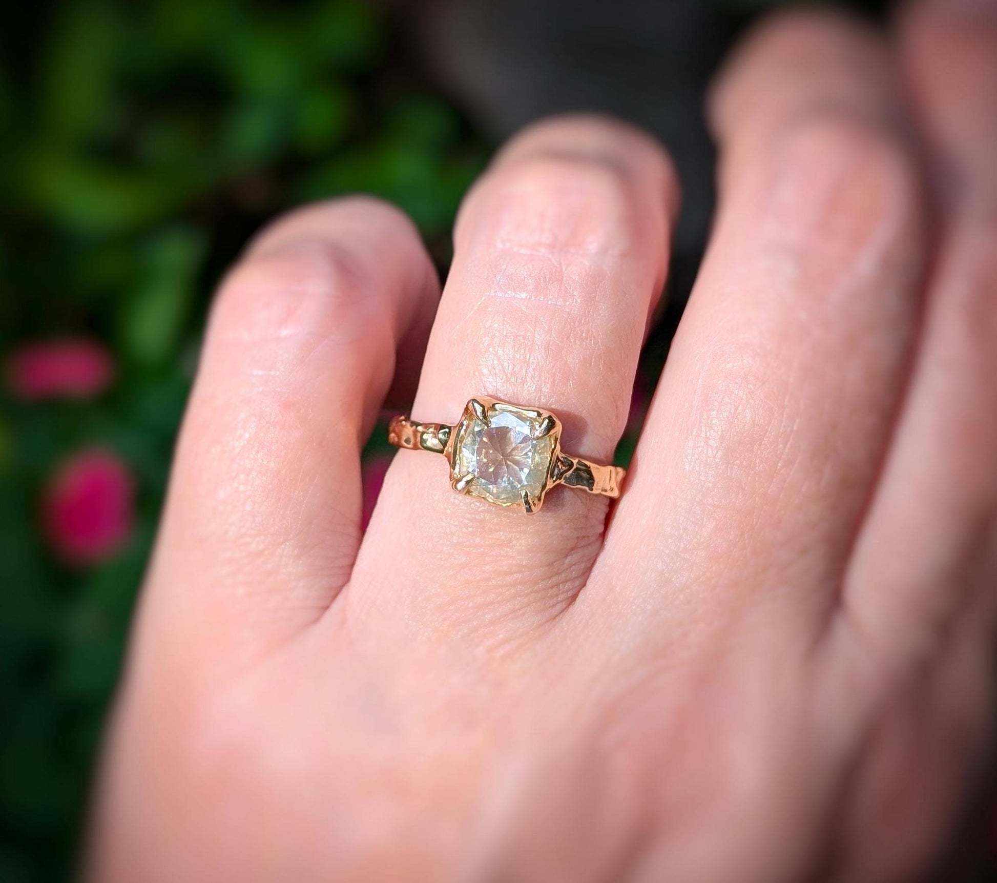 Gold Moissanite engagement ring featuring an 8mm cushion cut gem, showcased elegantly on a hand.