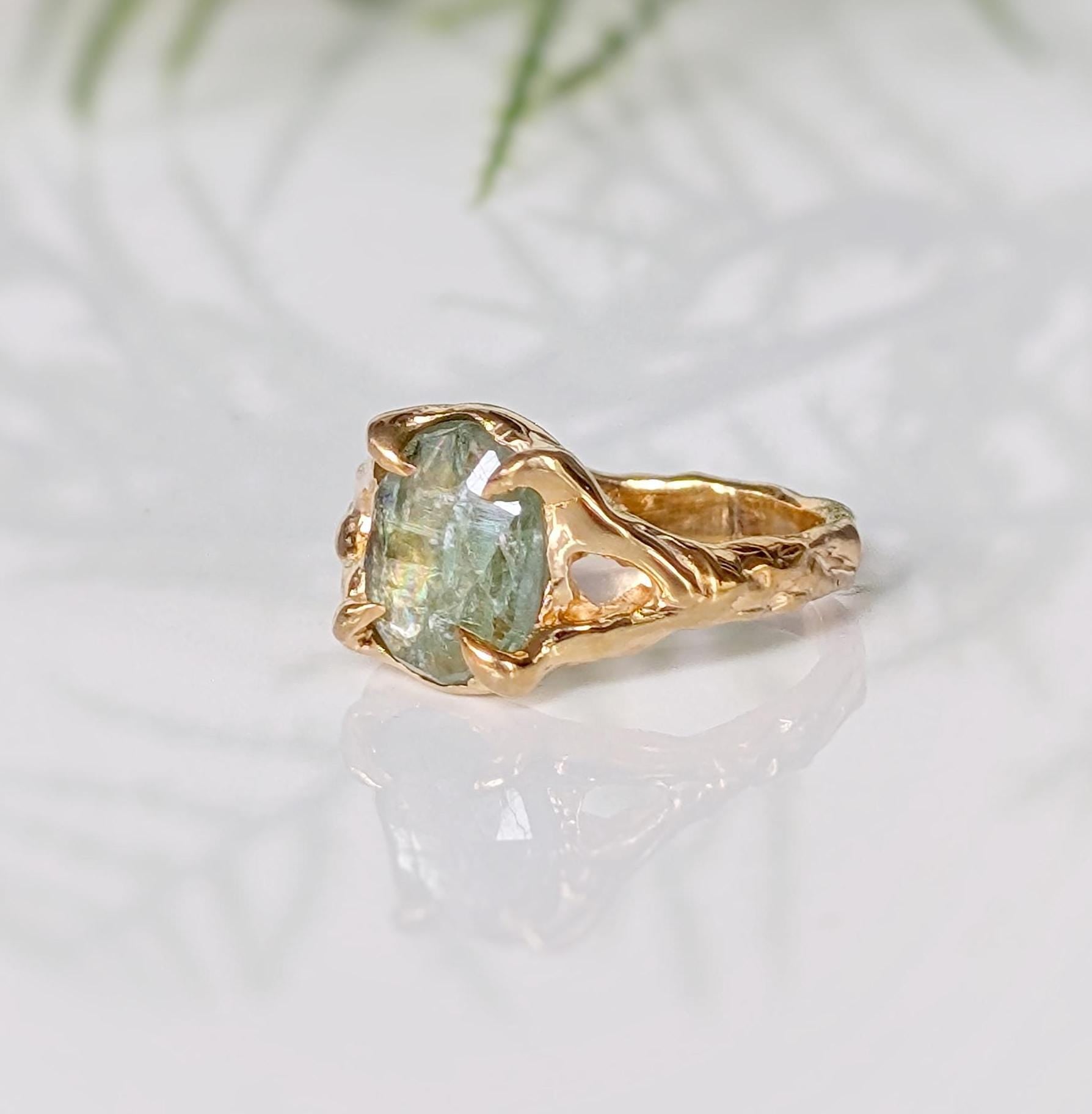 Solid 14k gold textured ring featuring a unique oval rose cut green Kyanite stone, showcasing artisanal charm.