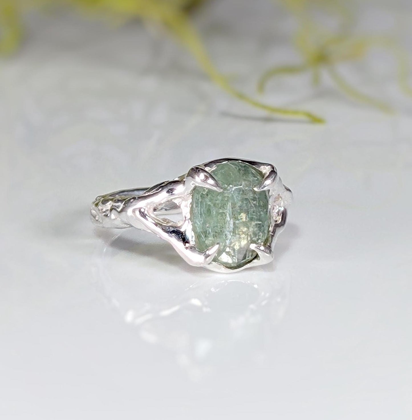 Sterling Silver ring featuring a textured band and a stunning oval-shaped green kyanite stone.