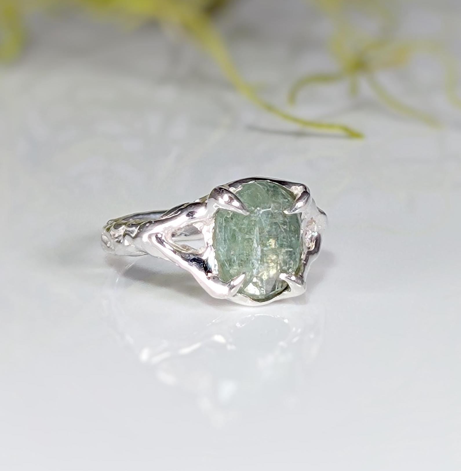 Sterling Silver ring featuring a textured band and a stunning oval-shaped green kyanite stone.