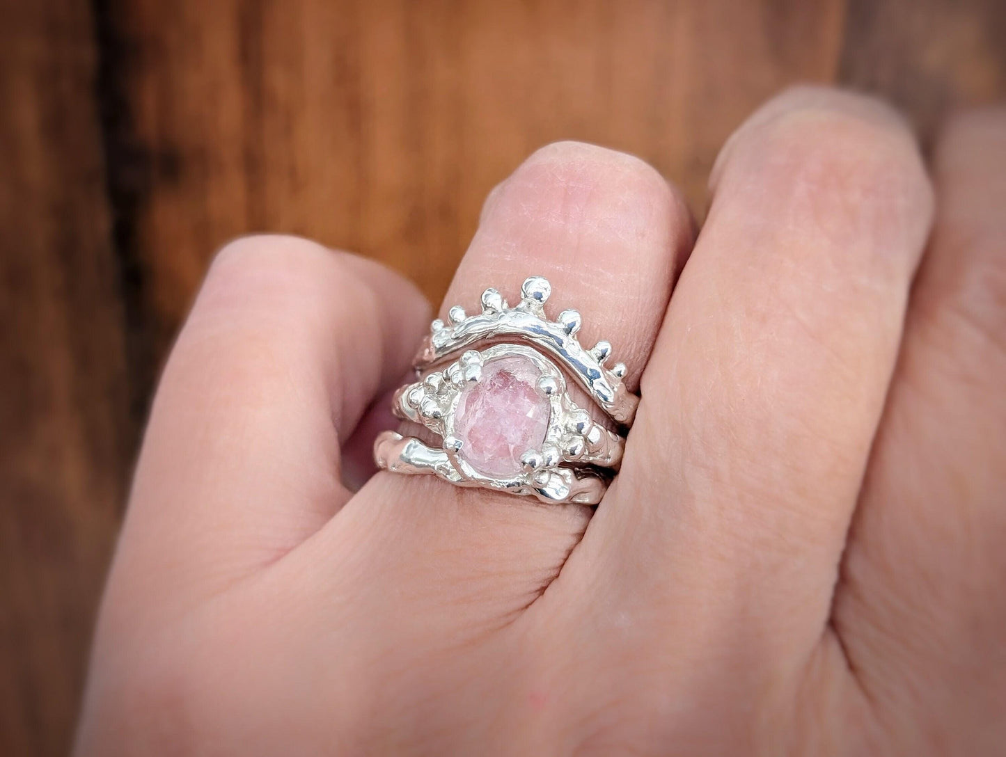Hand wearing a stunning Pink Morganite ring with a textured silver band, showcasing elegance and natural charm.
