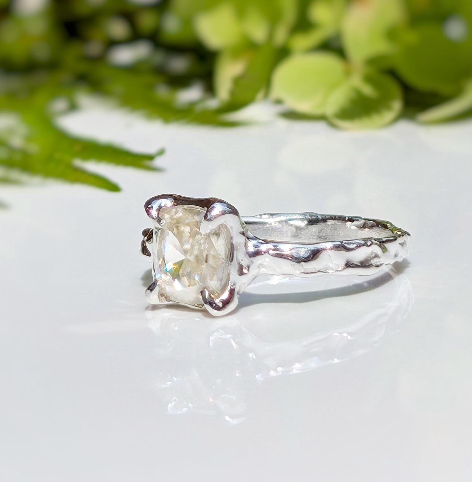 Unique Moissanite engagement ring featuring an 8mm cushion cut stone in a textured Silver setting.