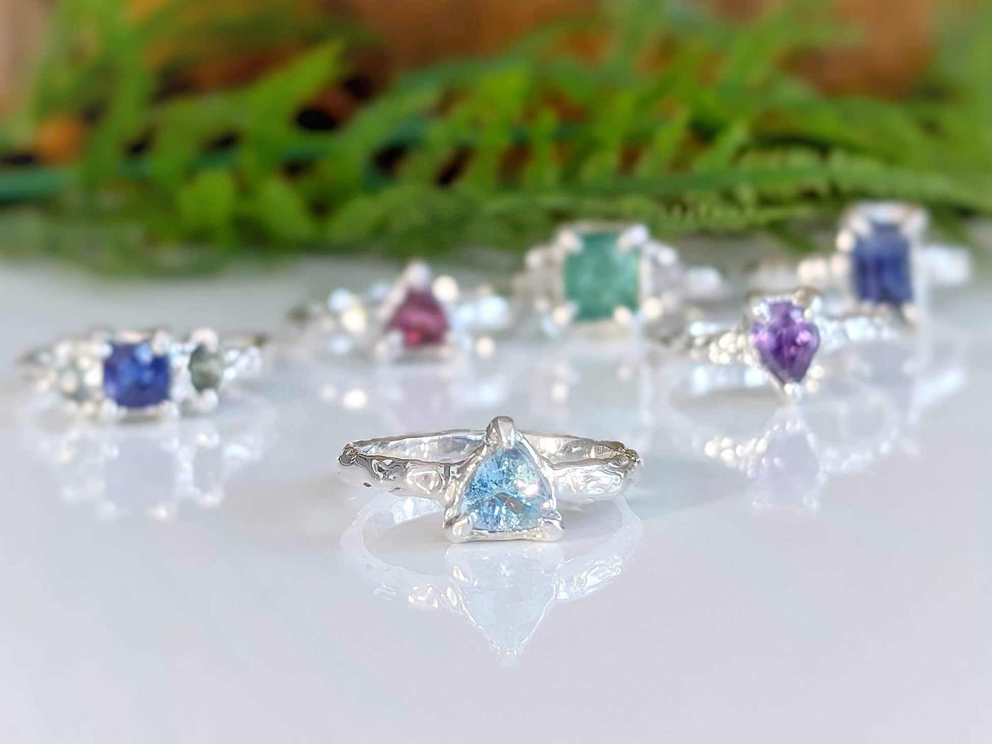 Sterling Silver Aquamarine ring showcased among various gemstone rings, highlighting its unique design and blue crystal.