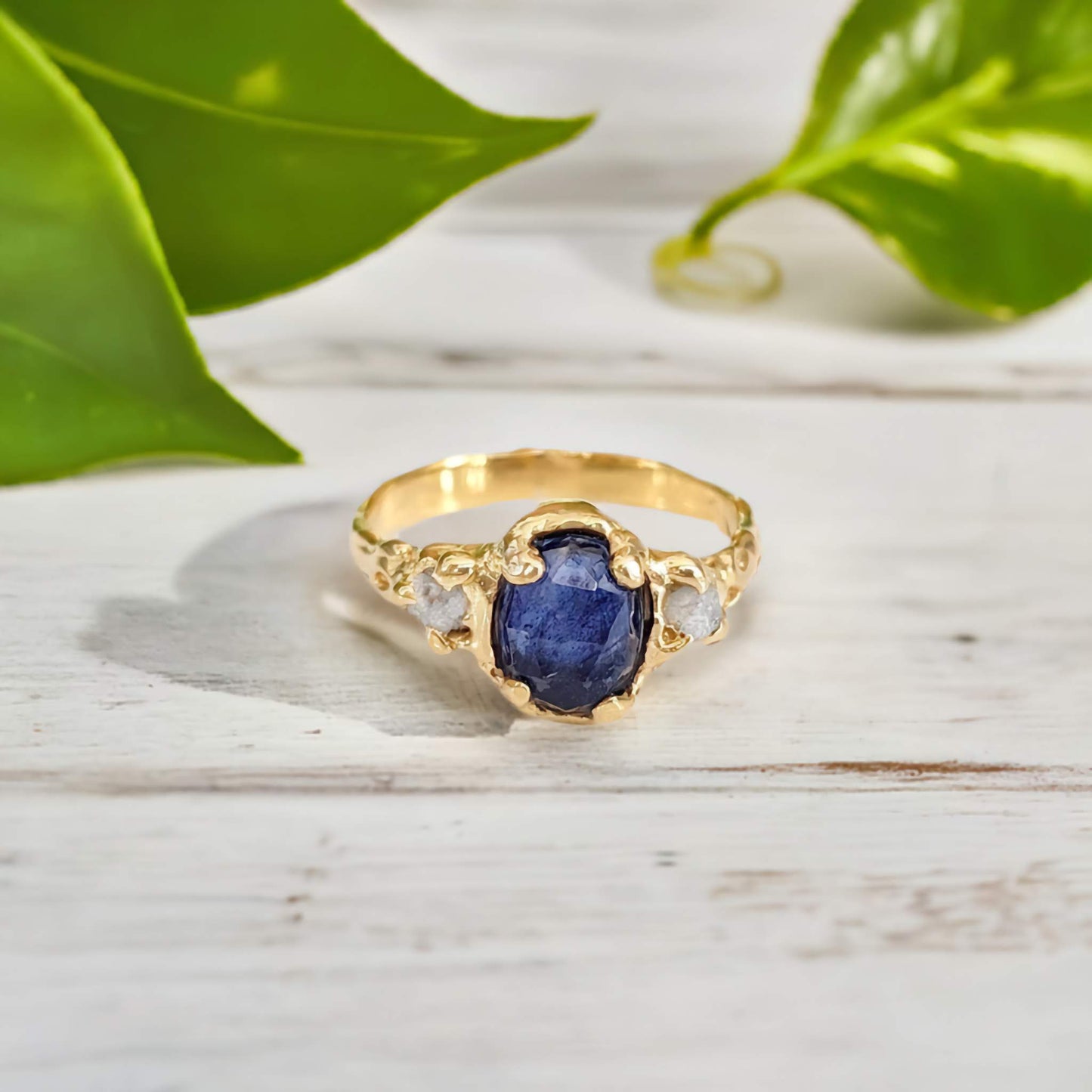 Oval Blue Sapphire and 2 small raw diamonds set by prongs on a textured Solid 14k Gold band