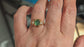 Woman's hand wearing a Raw mint green Emerald and diamonds set on Molten Gold prong setting