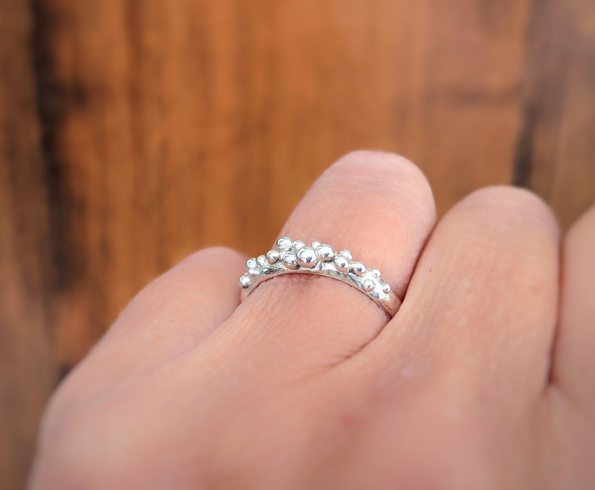 Woman's hand wearing a Molten Solid Sterling Silver granulated textured ring