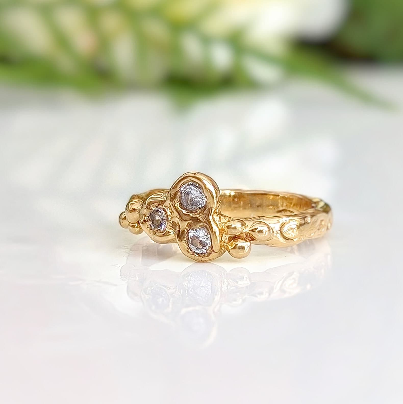 Cluster of 3 small Cubic Zirconias set by prongs on a textured Molten Solid 14k Gold band