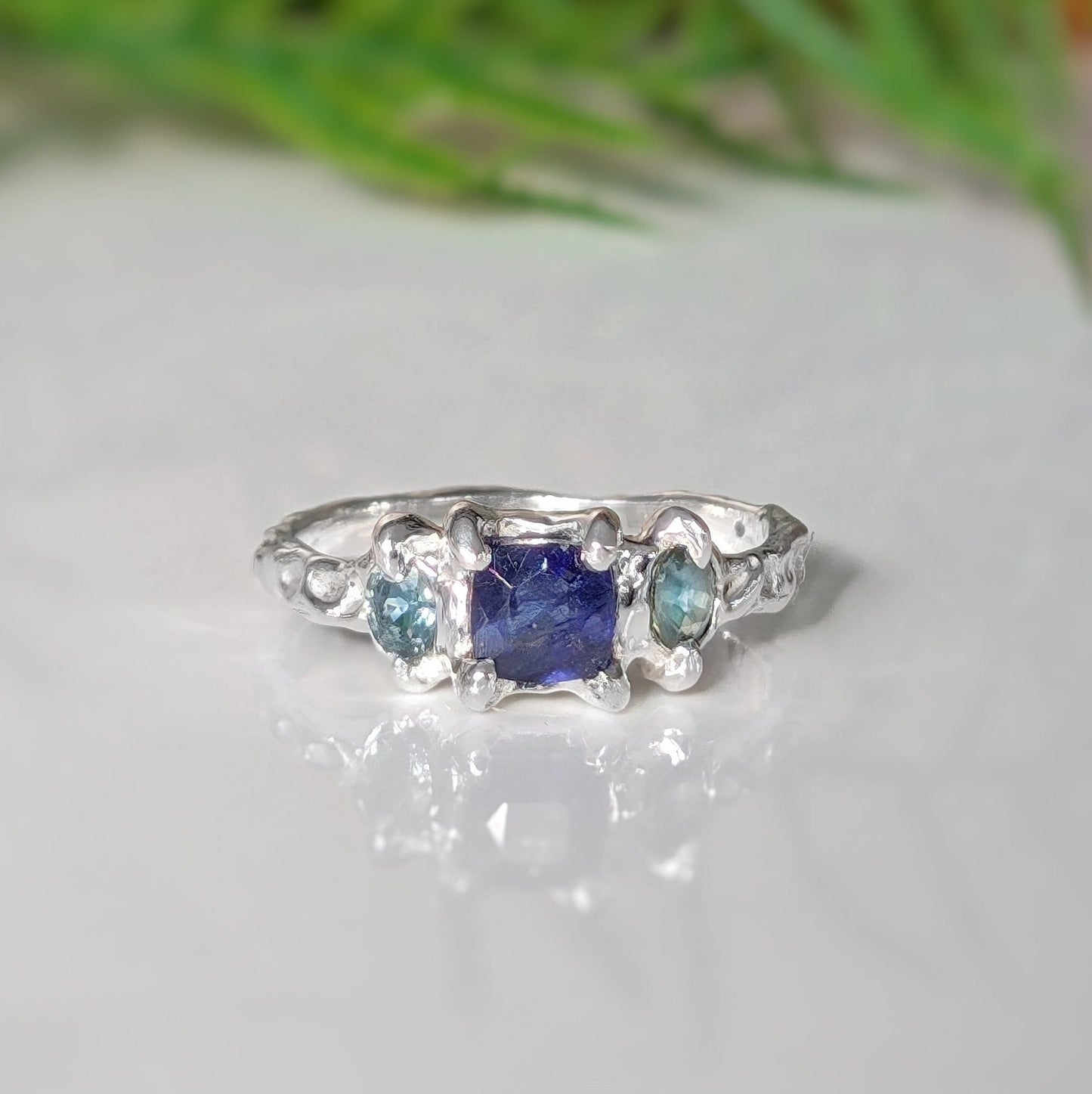 Square Blue Sapphire and 2 small green Tourmaline set by prongs on a textured sterling silver band